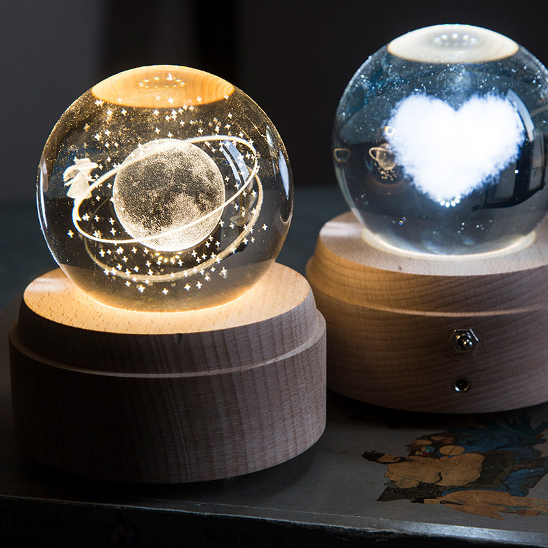 Bola de cristal giratoria caja de música LED base luminosa luz de la noche de dibujos animados pequeña base de la decoración