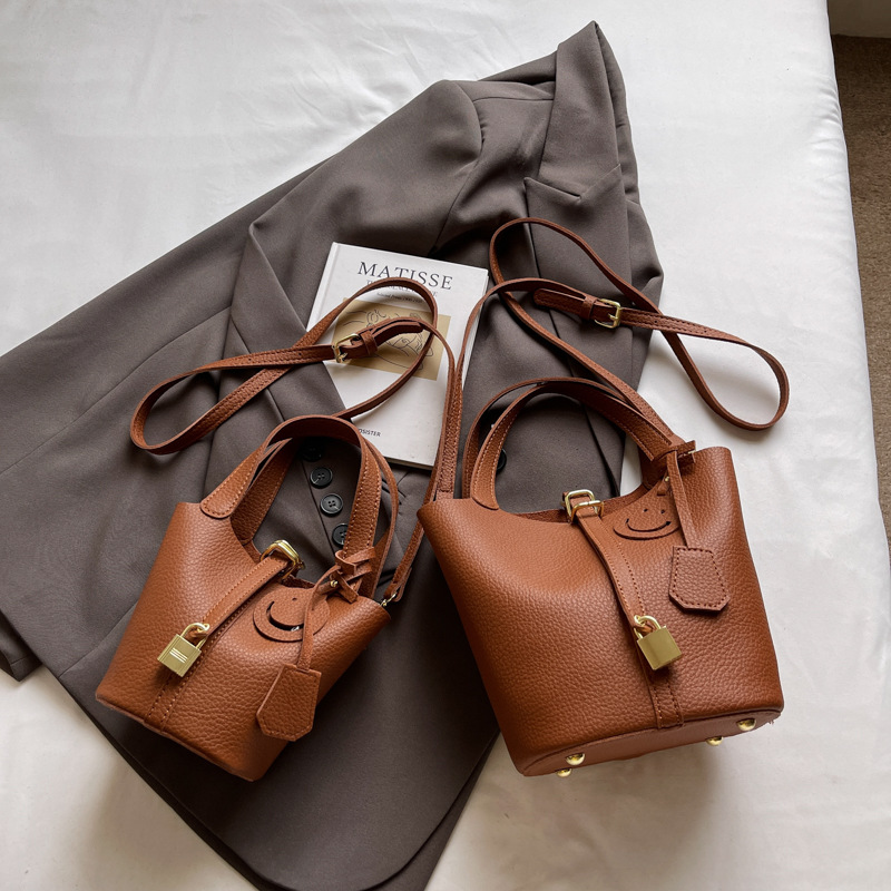 Bolso de cubo portátil con patrón de lichi de alta gama para mujer 2025 nuevo bolso de hombro de todo fósforo de moda bolso de mensajero casual de estilo occidental