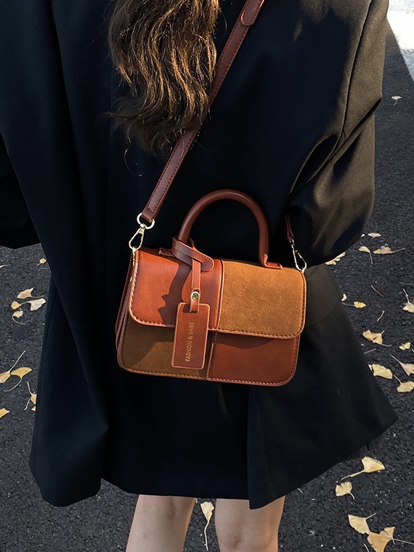Bolsos de mano de textura alta para mujeres 2025 nueva tendencia europea y americana cruzada retro empalme versátil mochila