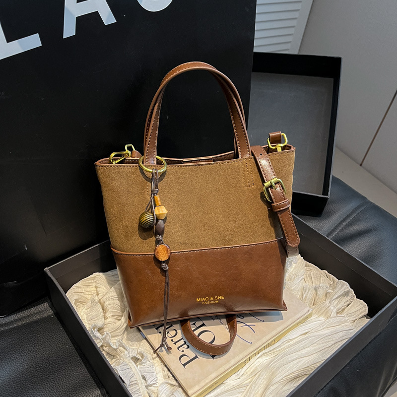 Bolsa de color retro de estilo extranjero para mujeres otoño y invierno 2025, nuevo tipo de bolso de hombro de viaje, bolso de cubo de mano de alta calidad