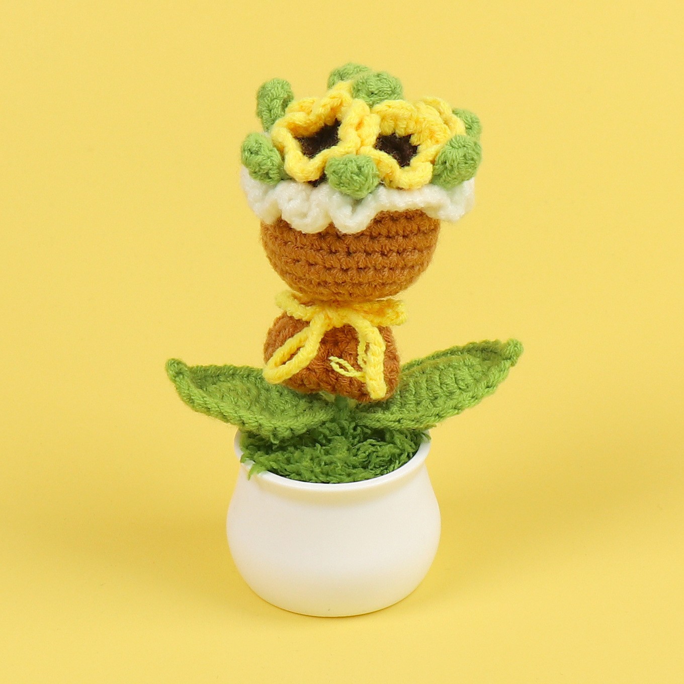 Maceta amarilla con flores en la mano