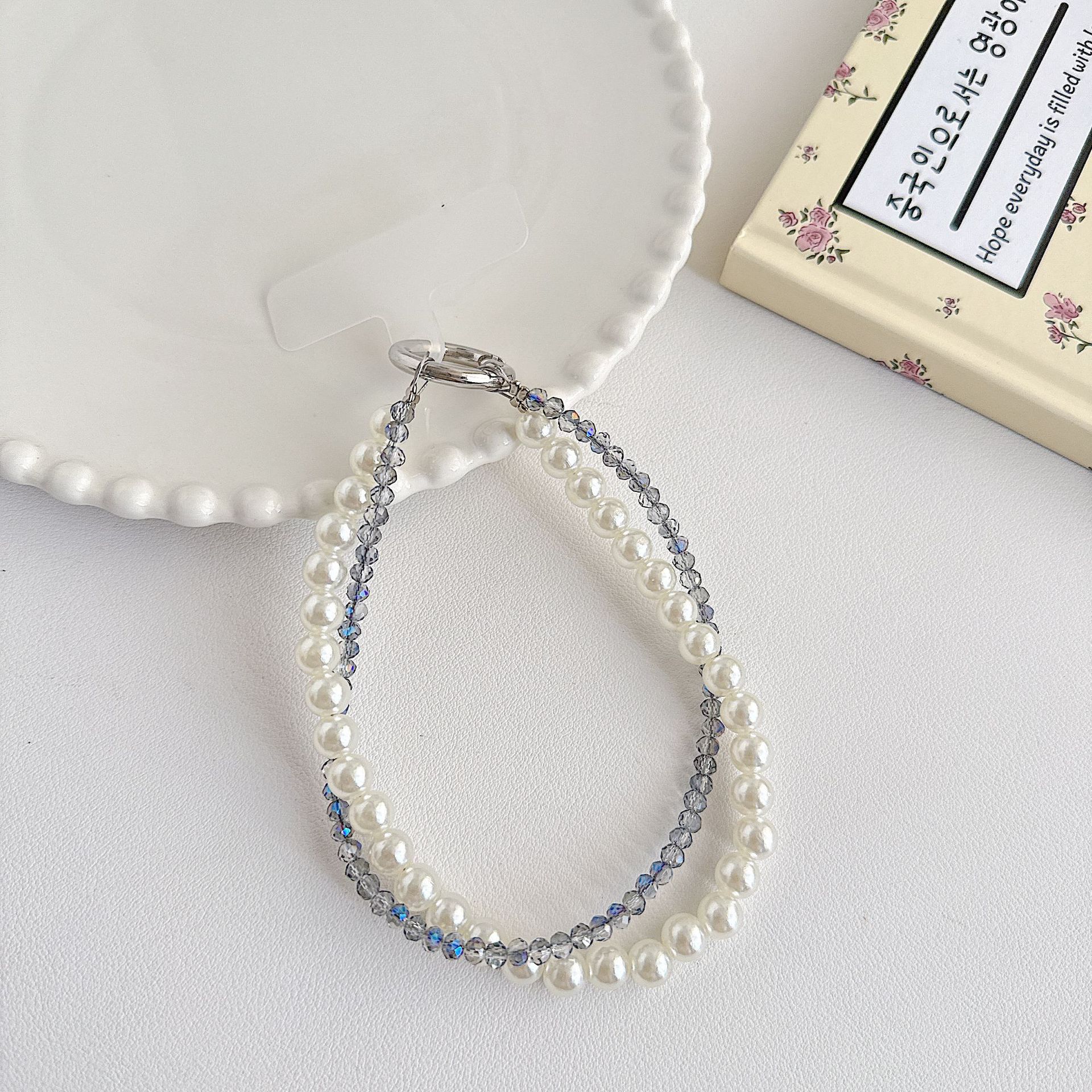 Boutique hecho a mano de alta gama teléfono móvil cadena colgante mujer estilo ins cristal coreano perla enrollamiento cadena de muñeca moda corta