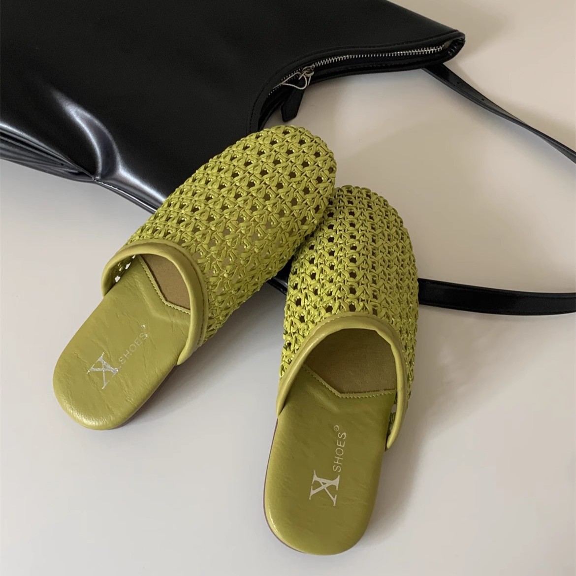 Versión de cuero suave tejida transpirable de un pie Mu Qin Boken zapatos exteriores 2025 verano nuevo estilo plano puntera media pantufla