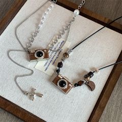 レトロな茶色のカメラの真珠のネックレスの女性の軽豪華な大衆の設計は百合の個性の長いチェーンのセーターのチェーンを飾っています。