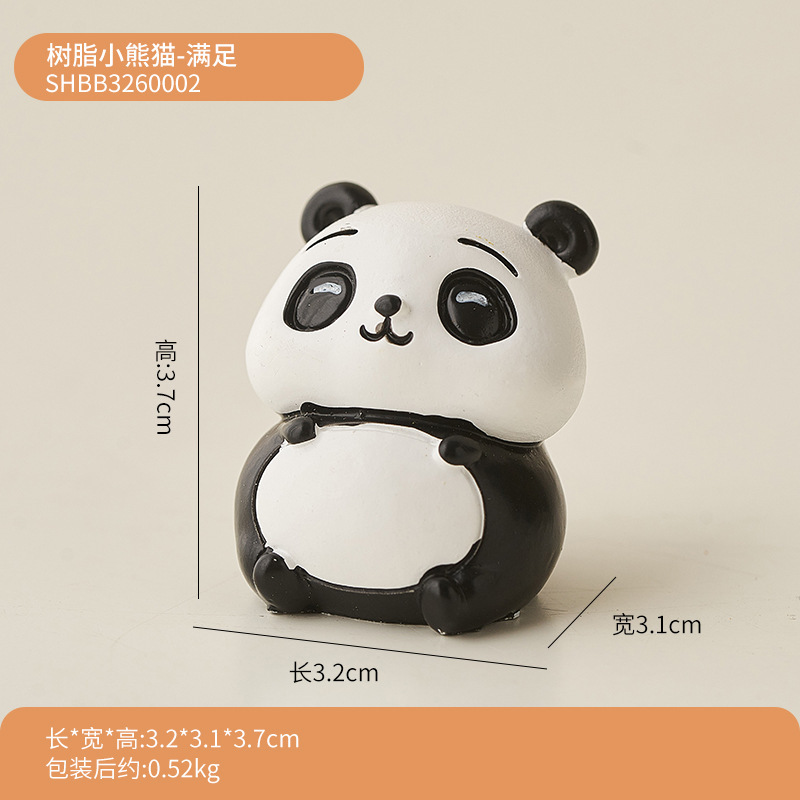 パンダのパソコンは腹ばいになってオフィスのデスクトップの装飾品を飾っています。|undefined