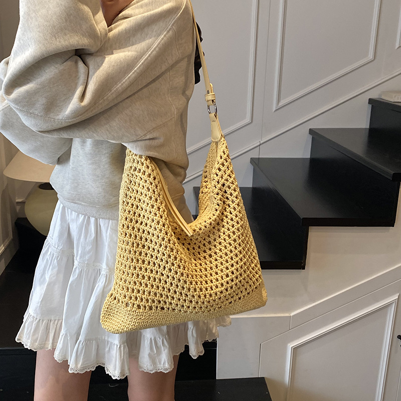 Venta caliente de verano nuevo producto bolsa tejida hueca para mujer 2025 bolsa de playa estilo vacaciones bolsa de paja de gran capacidad bolsa de cubo