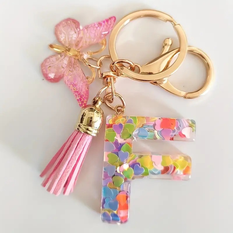 2024 transfronteriza en stock resina rosa con lentejuelas 26 letras inglesas llavero colgante mariposa borla Accesorios