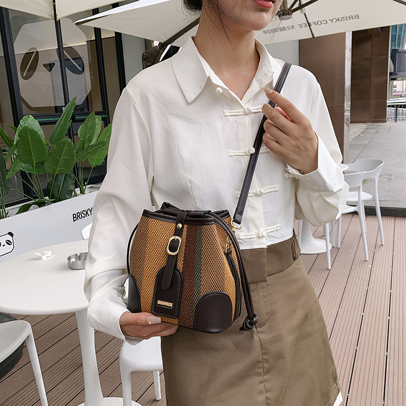Diseño de nicho de moda bolsa de cubo portátil para mujeres 2023 nueva moda lienzo contraste color rayas hombro bolsa de mensajero