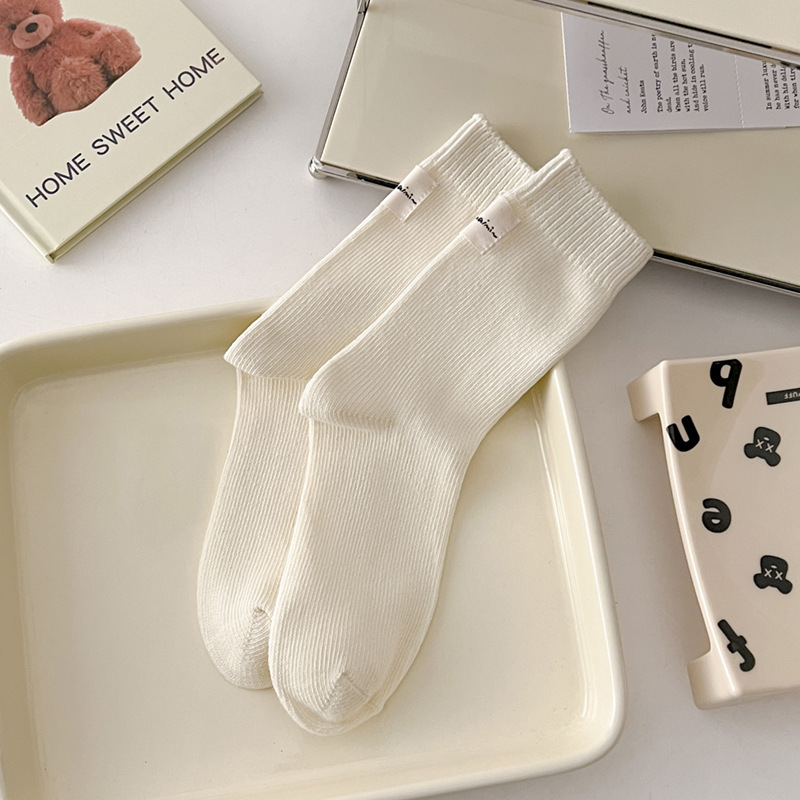 Otoño e invierno Nuevos calcetines de algodón absorbentes de sudor calcetines de pila serie de crema para mujer estilo ins Corea del Sur etiqueta de tela calcetines de media pantorrilla moda