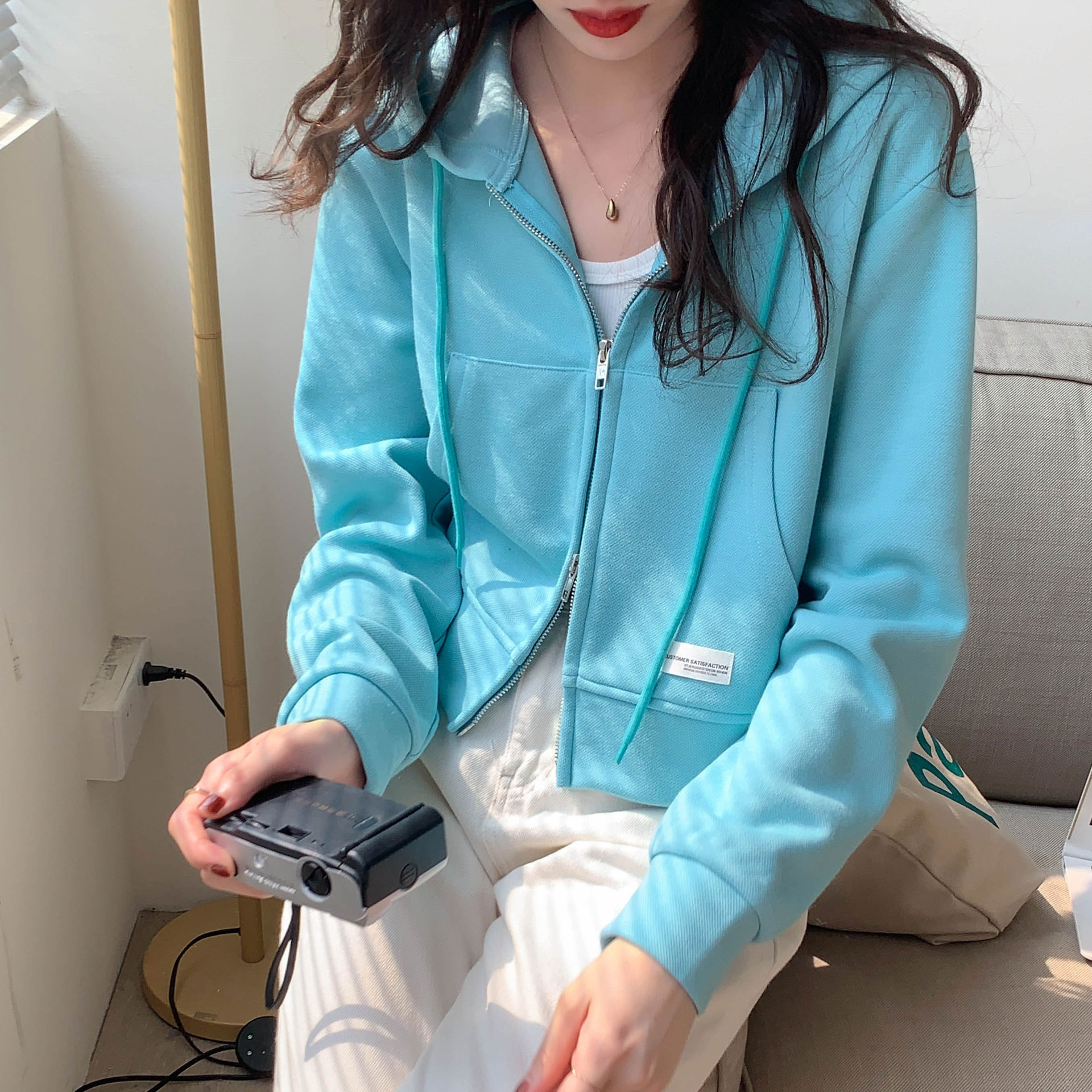 Venta al por mayor suéter delgado de las mujeres de cremallera corta de color sólido diseño de nicho de primavera y verano corto Top casual con capucha cardigan