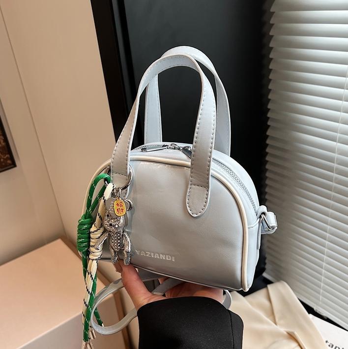 Bolsa de bolos para mujeres 2025 nuevo bolso de hombro de mano de color universal nicho simple de moda alta sensación de mochila