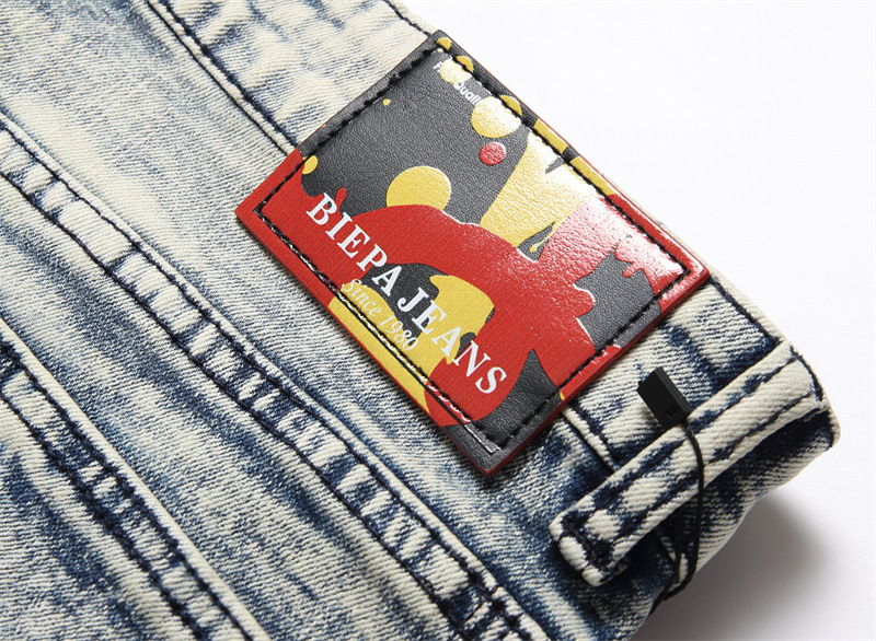 Spodnie jeansowe męskie z elastycznymi, perforowanymi, nadrukowanymi, patchworkowymi wstawkami, dopasowane do sylwetki_voghion.com