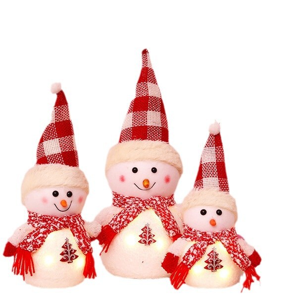 クリスマス発光雪だるま人形のデスクトップに子供の祝日のプレゼントを飾っています。|undefined