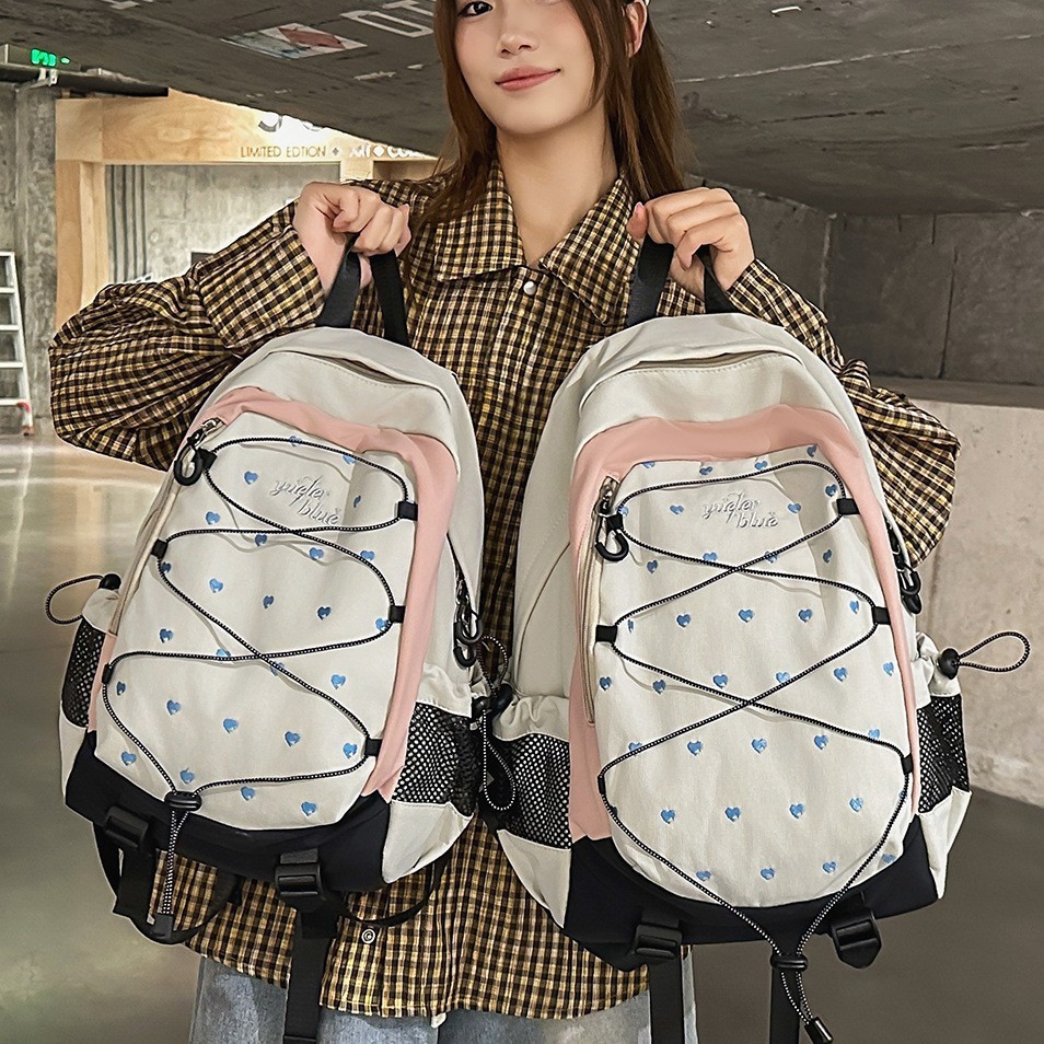 White and pink heart-printed backpack in a sweet and cool style for girls, suitable for students, campus commuting, outdoor travel, and sports