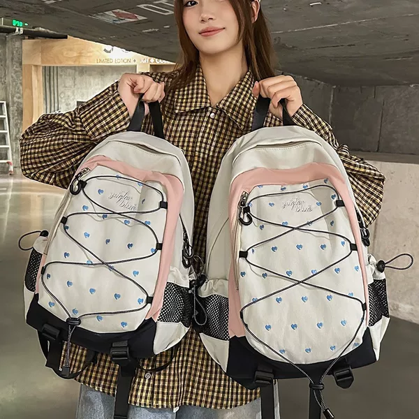 White and pink heart-printed backpack in a sweet and cool style for girls, suitable for students, campus commuting, outdoor travel, and sports