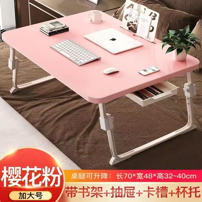 ベッドの上の小さい机のノートパソコンの机の上で折り畳みます。|undefined