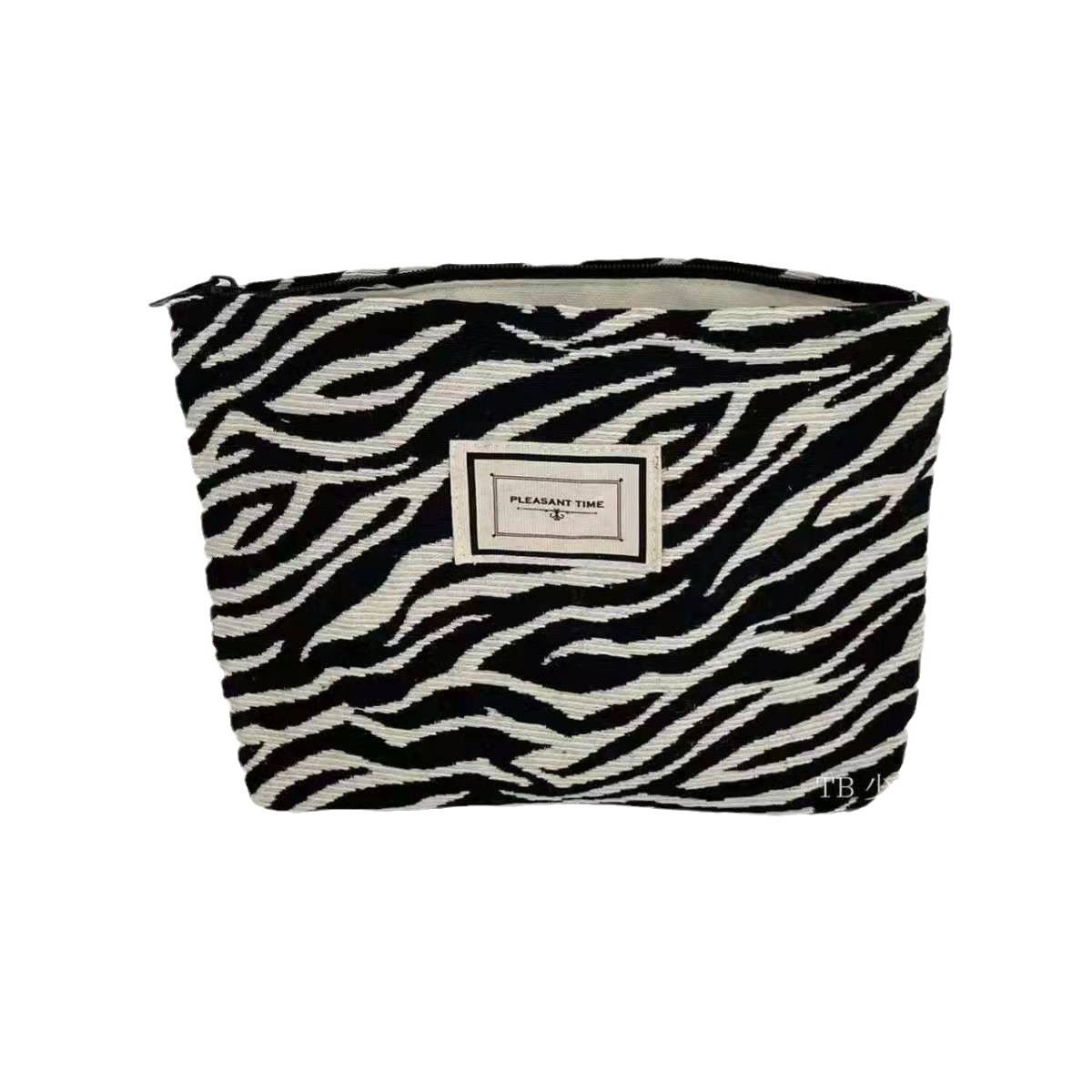 Versión coreana de la bolsa de cosméticos con patrón de cebra, portátil de gran capacidad, bolso de mano con sentido avanzado, bolso de almacenamiento de lavado de viaje, damas
