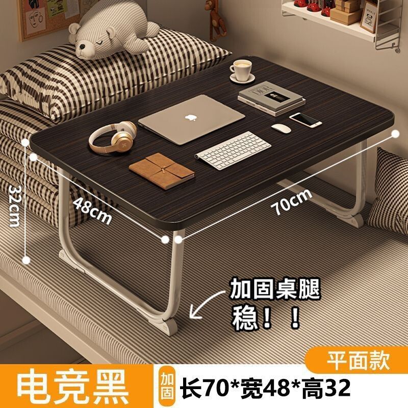 ベッドの上の小さい机のノートパソコンの机の上で折り畳みます。|undefined