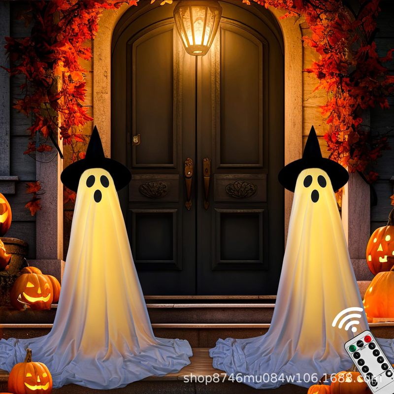 前の玄関に帽子をかぶって光る幽霊ハロウィーンは鬼の玄関の庭の幽霊ハロウィーンの装飾を立てます。|undefined