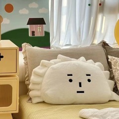 赤い本の同じタイプの水ギョーザは枕を抱いてソファーの寝室のベッドの上で枕を支えて寝ます。ぬいぐるみは彼女にプレゼントします。