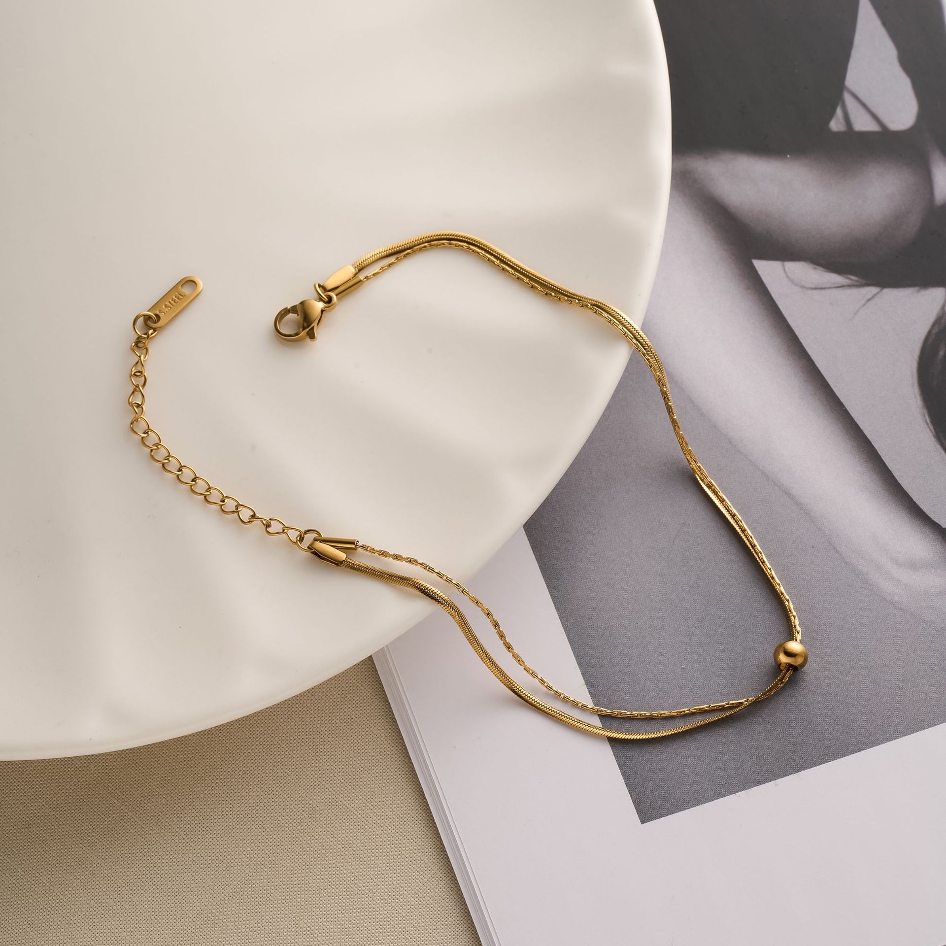 Nuevas cuentas de acero de titanio, tobillera de doble capa móvil, cadena de hueso de serpiente, bola de oro pequeña, verano de oro de 18k, nuevo adorno de pie de todo fósforo