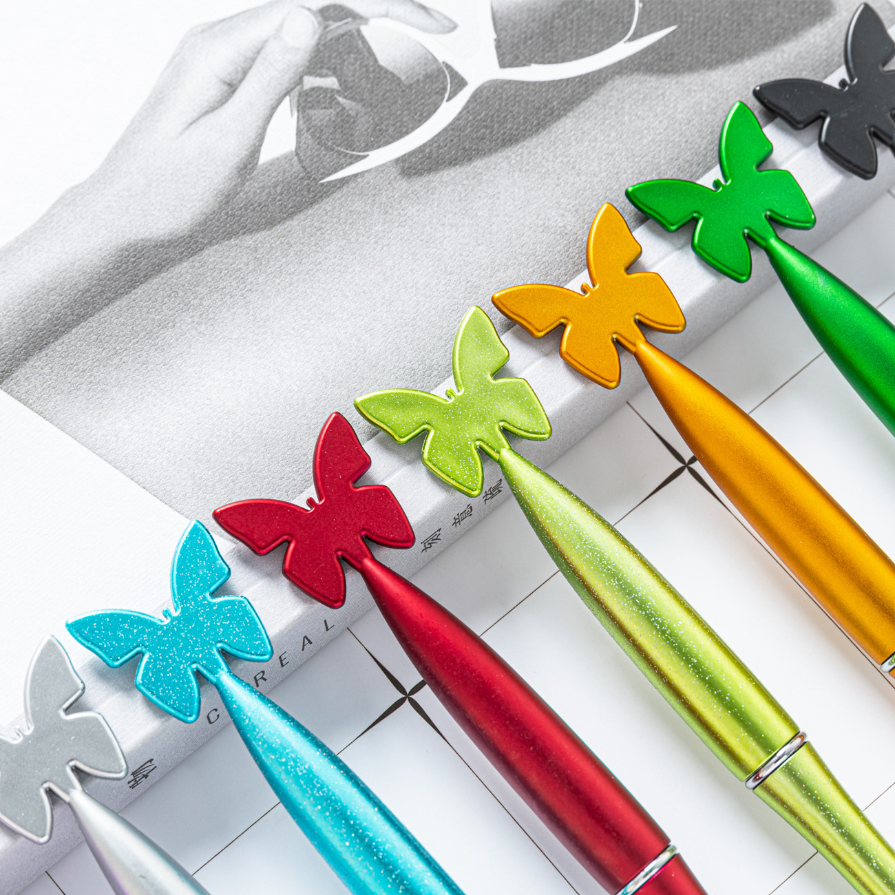 Creativa mariposa plástico torsión lápiz de plástico color pulverización al por mayor pluma de plástico multicolor puede imprimir logotipo publicitario lápiz de bola