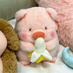 かわいいバナナlulu豚ぬいぐるみ人形が枕を抱いてベッドの上の人形を温かくして彼女の誕生日プレゼントに付き添う