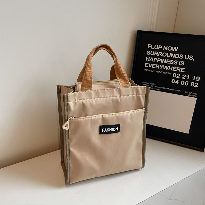Moda coreana nueva serie de gran capacidad bolsas escolares portátiles de otoño 2024 bolsas de botellas impermeables Oxford