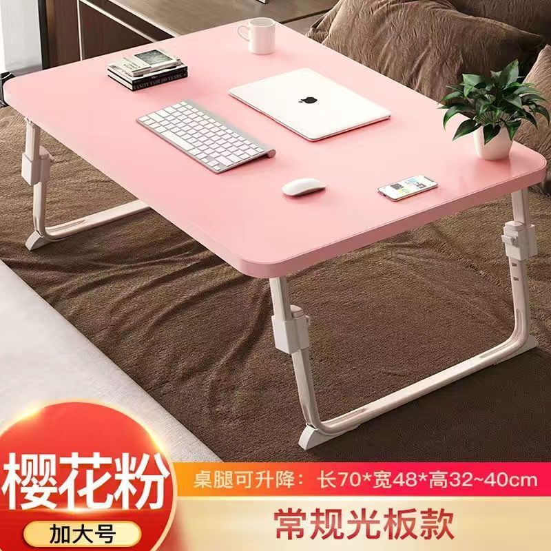 ベッドの上の小さい机のノートパソコンの机の上で折り畳みます。|undefined