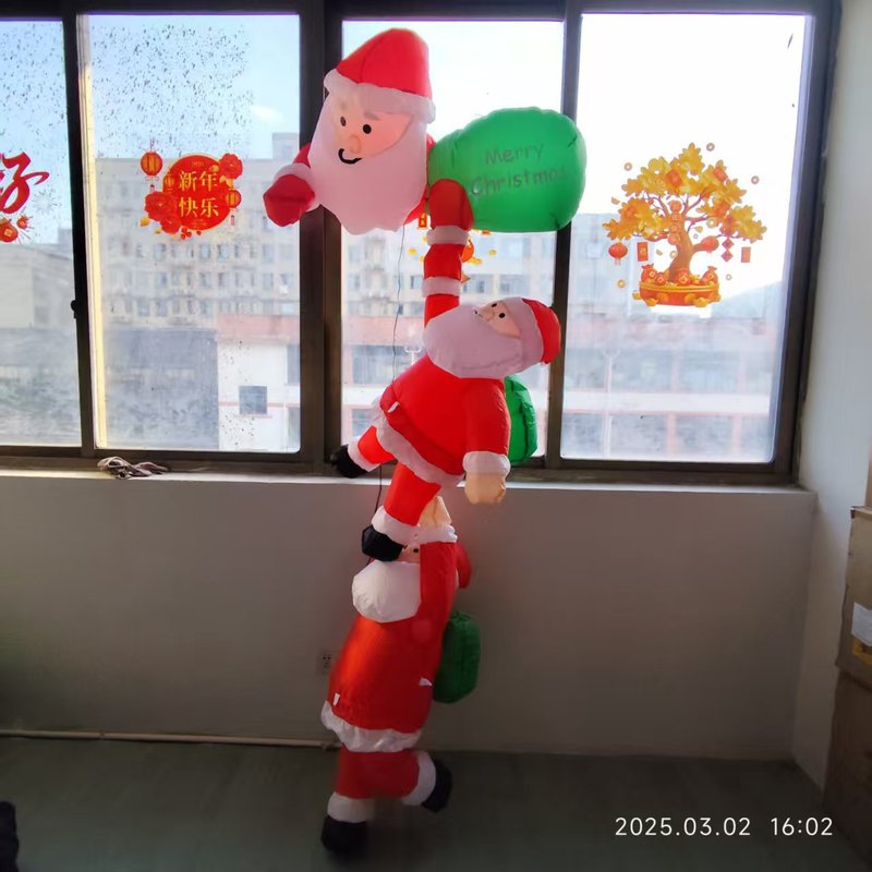 国境を越えて2メートル3人のサンタクロースが壁に登ってクリスマスの屋外の飾りを入れる|undefined