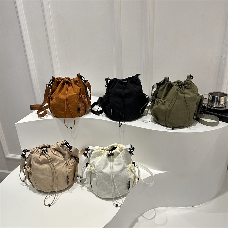 2025 verano nuevo nicho japonés y coreano tirar de la correa de tela de un hombro mochila de mujer ligera perezosa bolsa de cubo de feng shui