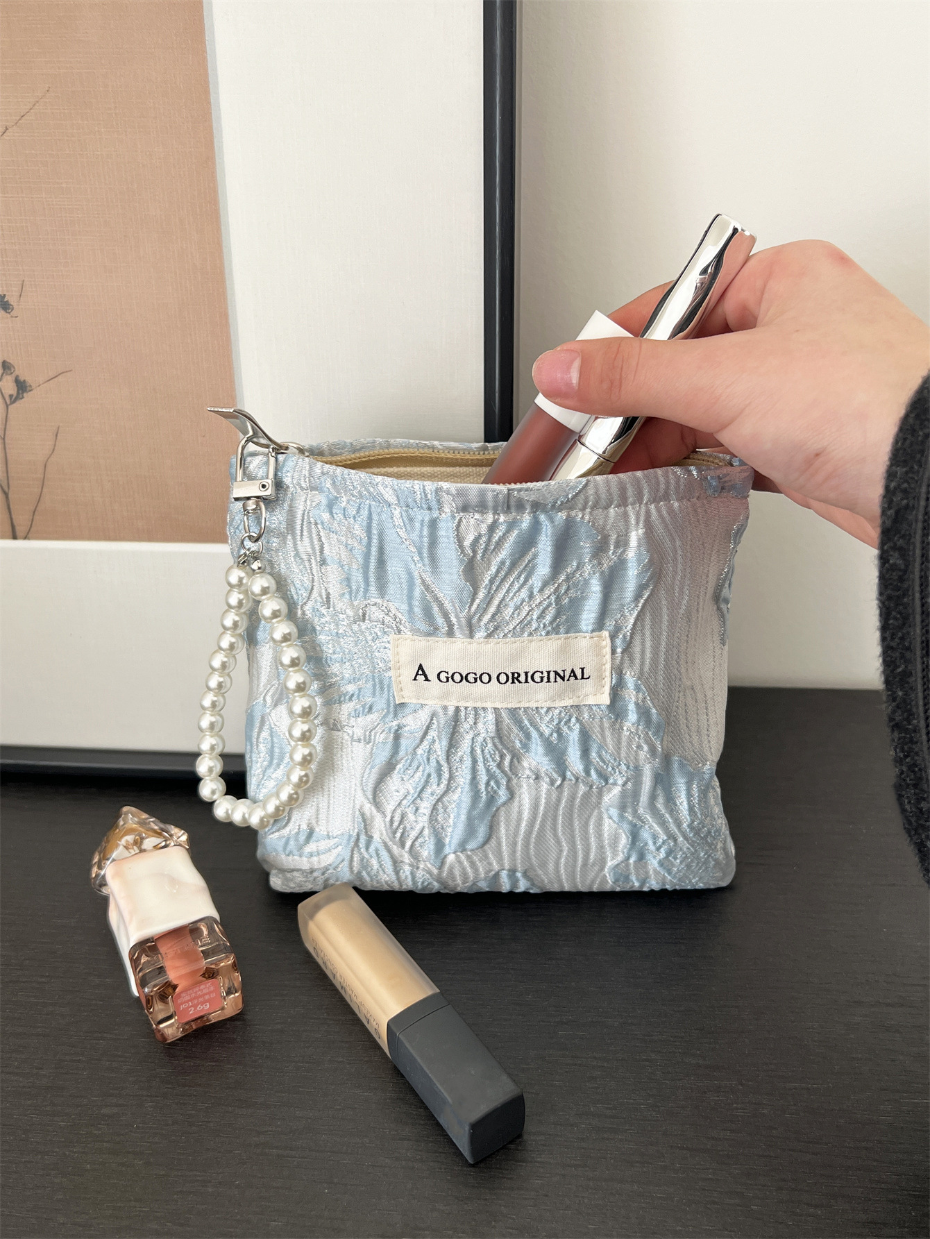 トランペットの高級感のある手は化粧バッグを持っています。布芸の財布を持っています。