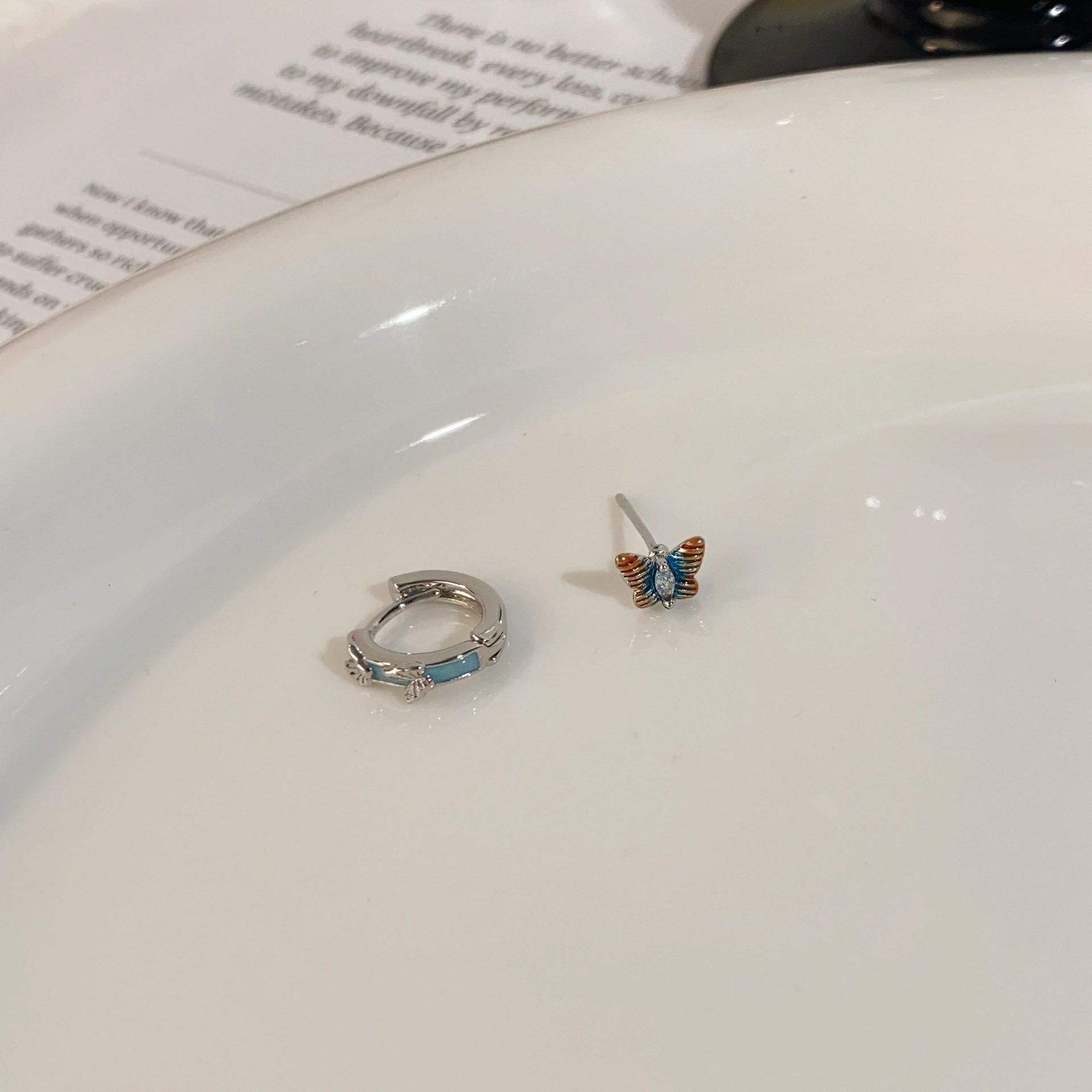 Green dripping butterfly earrings, one stud and one buckle each