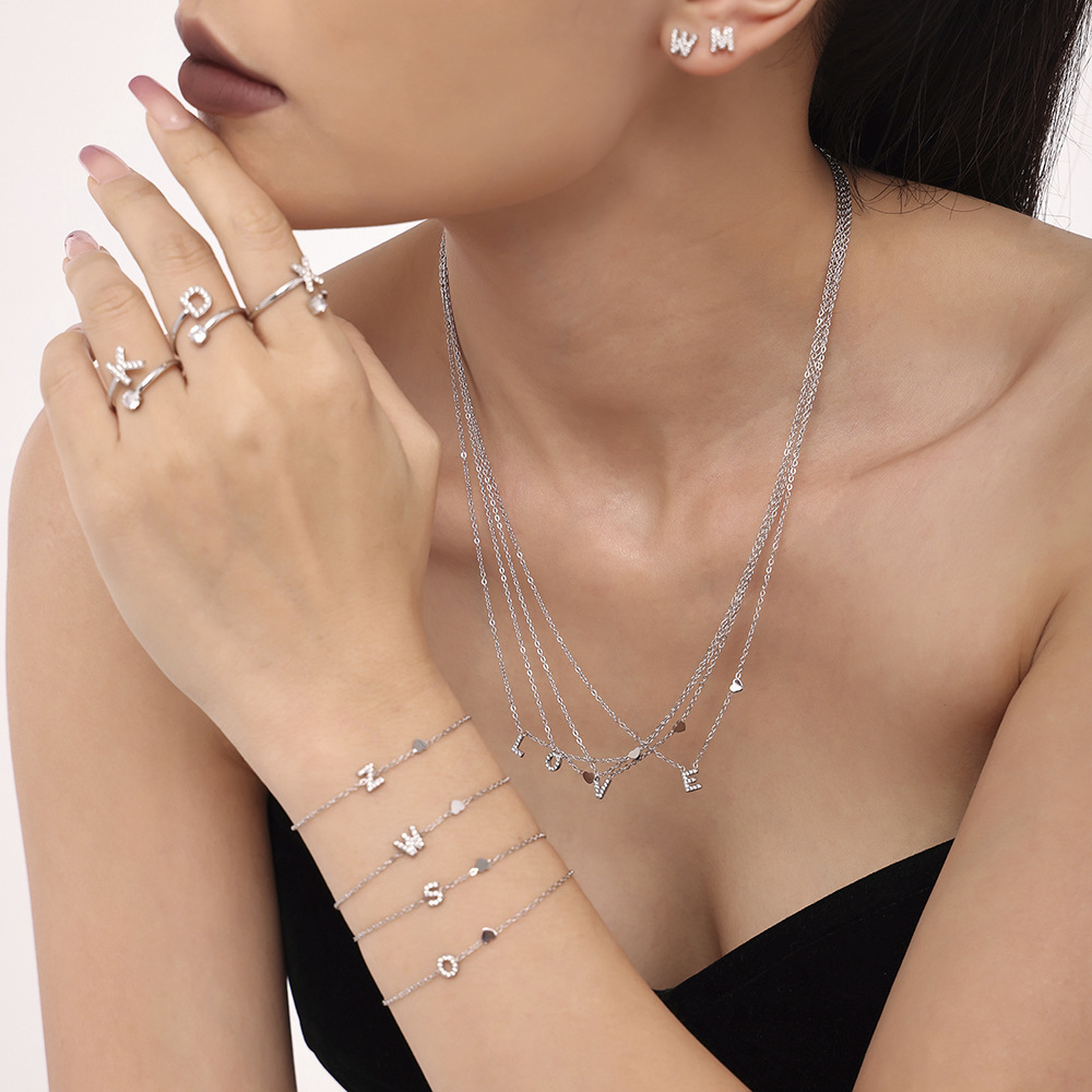 Qiong Yao Titanium Steel 26 letras con incrustaciones de circón Juego de joyas PVD chapado en oro real collar de retención de color pulsera anillo aretes