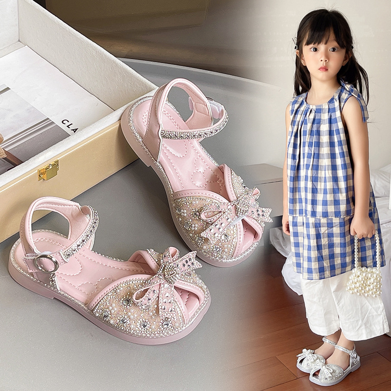 Sandalias Baotou para niñas 2025 verano nuevo estilo bowknot moda cristal princesa zapatos de playa para niños de suela suave marea
