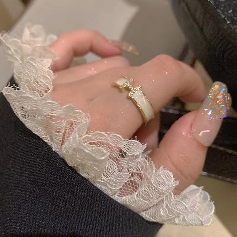 Brand white ring with letters with zircon