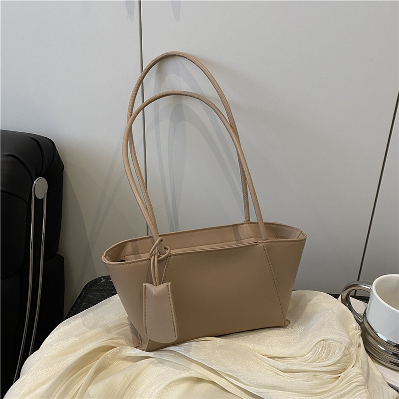 Sommer 2025: Koreanische Mode – Handtasche im schlichten, strukturierten Nischendesign, schulterfrei, quer über der Schulter, auch als Achseltasche tragbar._voghion.com