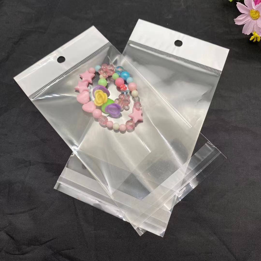 东莞厂家供应OPP自粘卡头袋硅胶挂绳白色吊卡塑料袋拉菲䓍饰品袋