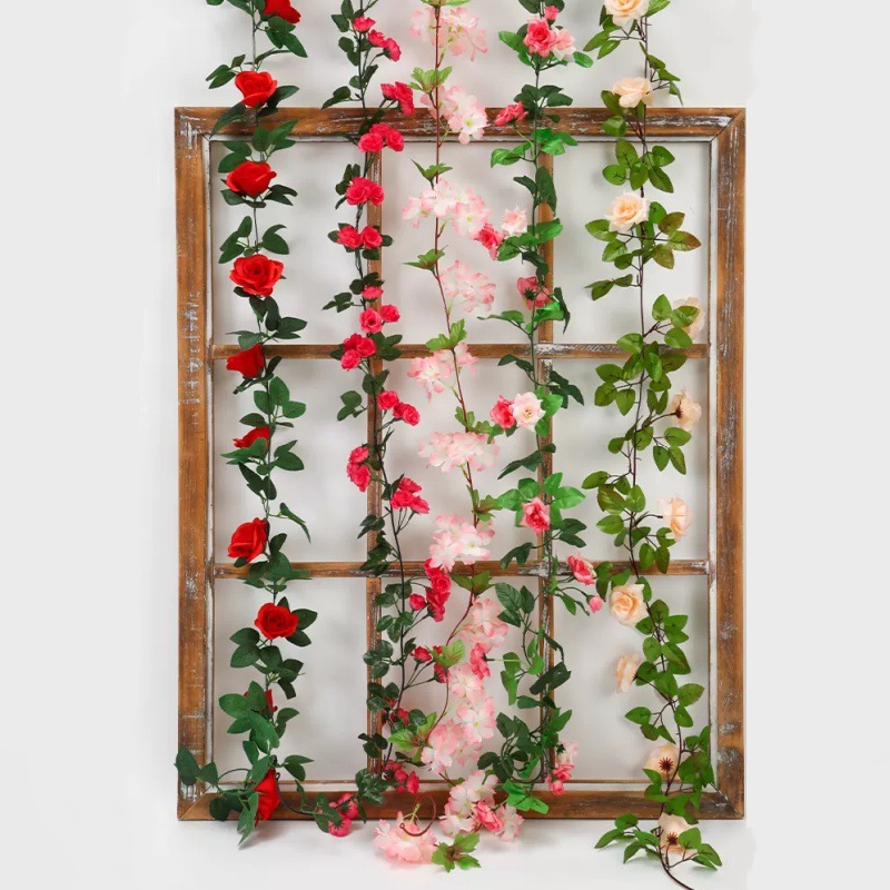 Simulación de flores falsas rosas de caña colgando la pared tubería de drenaje envuelta hoja verde que cubre la parte superior de la decoración de boda de plástico