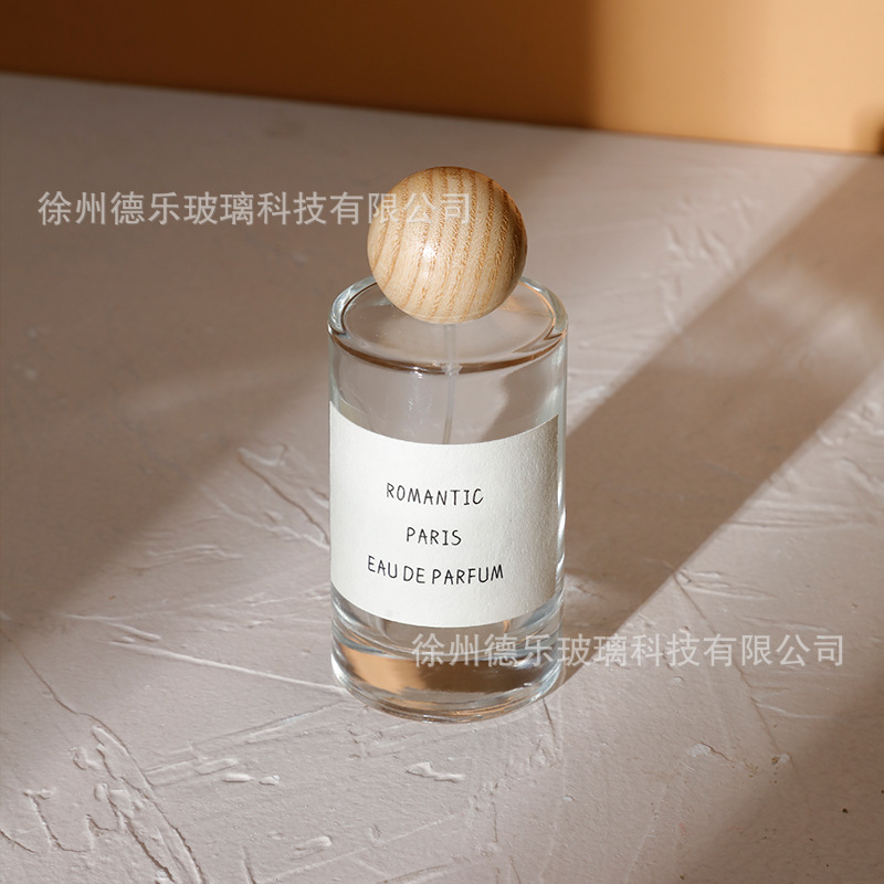 Venta al por mayor 50ml botella de perfume de vidrio cilíndrico botella de spray de perfume Cosméticos líquidos sub-botella con cubierta de bola de madera