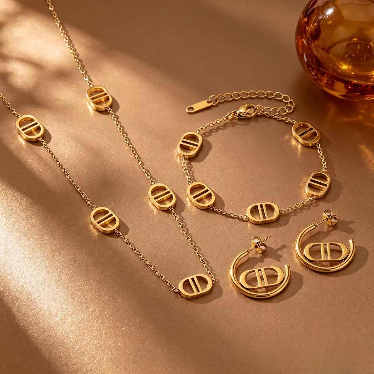 Popular European and American light luxury titanium steel 18K gold-plated double D hollow oval necklace, bracelet, and earrings three-piece set for women