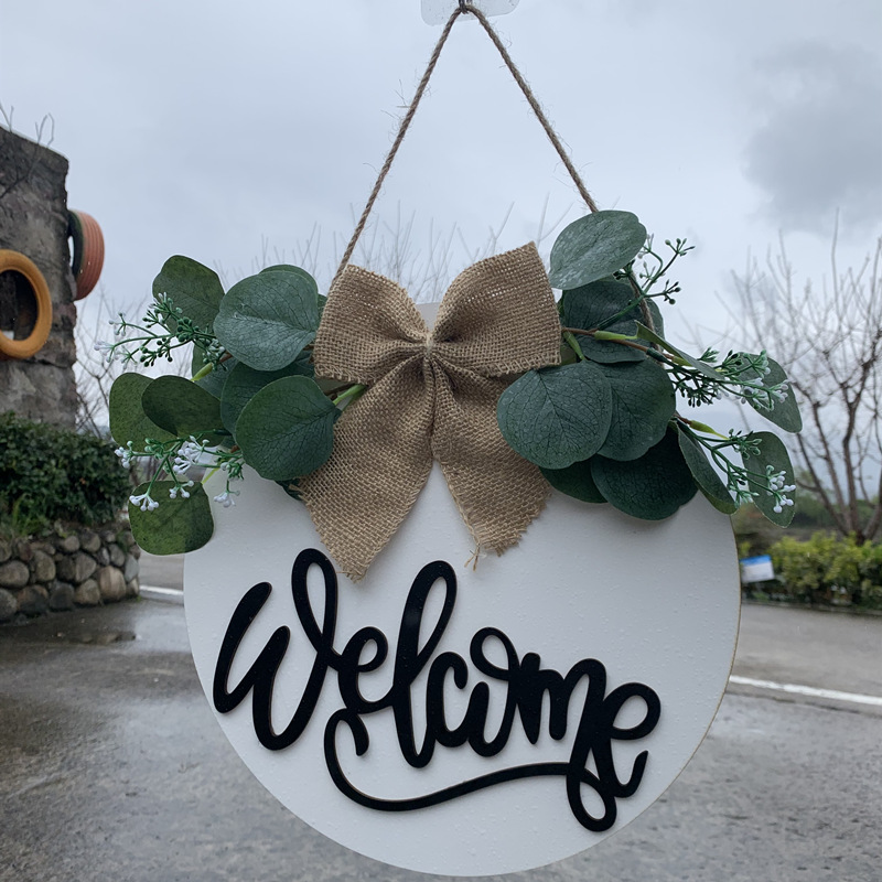 Olá estilo rural. A decoração circular inacabada da porta da frente recebe etiquetas e placas de madeira penduradas_voghion.com