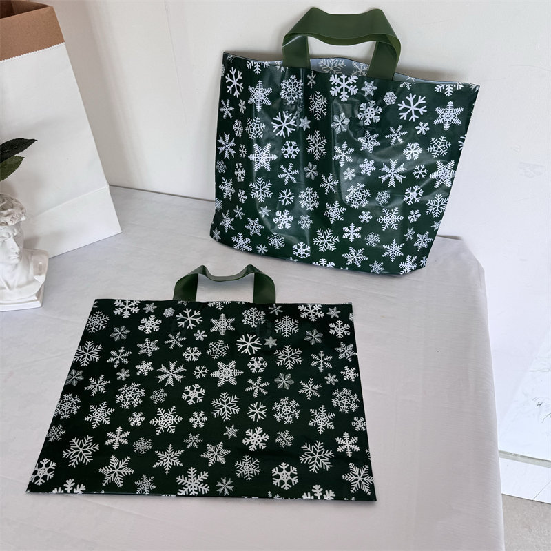 クリスマスの祝日の緑の厚いプラスチックの贈り物の服の店は手提げの袋の包装で厚いショッピングを包装して祝い事を包装します。|undefined