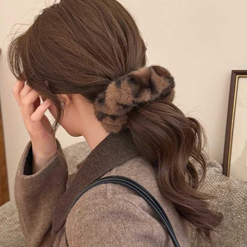 レトロなぬいぐるみのヒョウの紋様の大腸の髪の輪の女性は髪の毛の縄の団子の頭の馬尾の縄の冬の毛の皮の筋の頭を刺します。|undefined