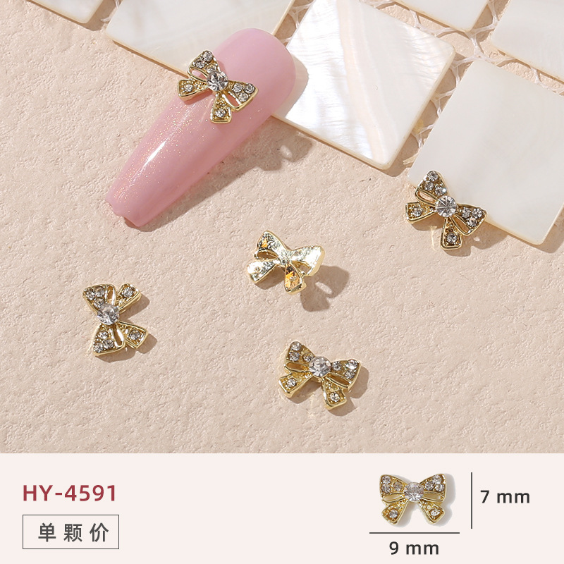 Uñas mariposa joyería nueva línea popular perla arco metal decoración de uñas pequeños accesorios de joyería al por mayor