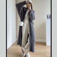 ミンクのセーターのコートの女性はだらだらしています。