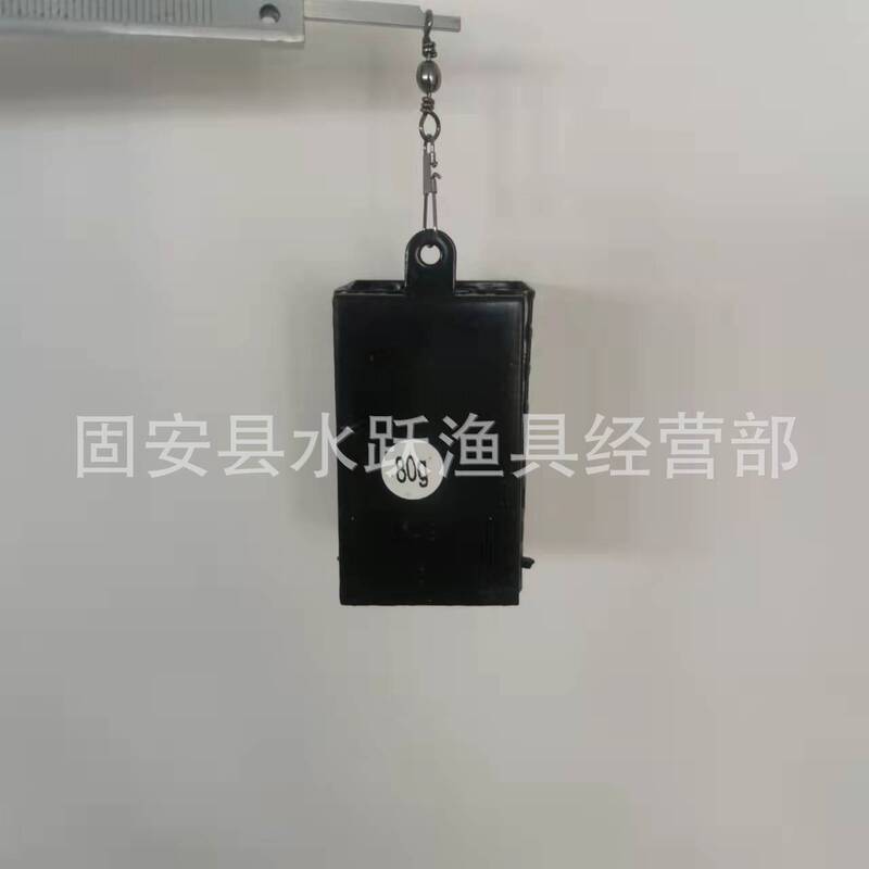 黒い四角形の丸い鉄の餌のかごに餌の道具が付いています。|undefined