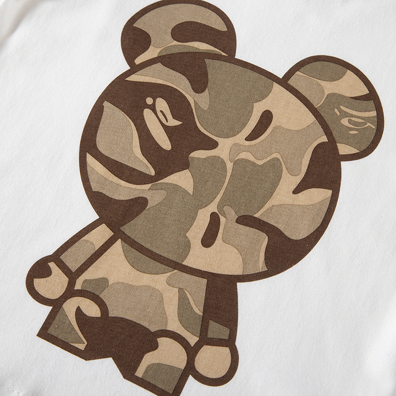 Ropa infantil nueva de otoño 2025, camiseta de manga larga para niños con diseño de oso de camuflaje en bloques de color, cuello redondo de algodón puro, top infantil.