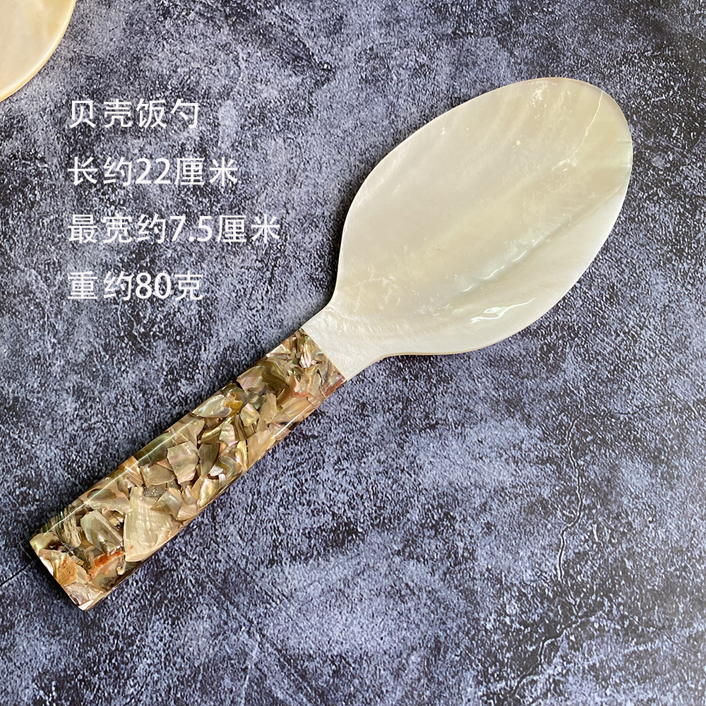 노란색 손잡이가 달린 흰색 조개 밥숟가락