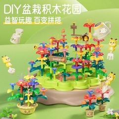 子供の百変の積み木の花園の鉢植えの積み木の植木鉢は水をやります。